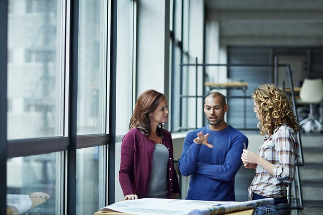 A group of employees discuss how to improve business operations.